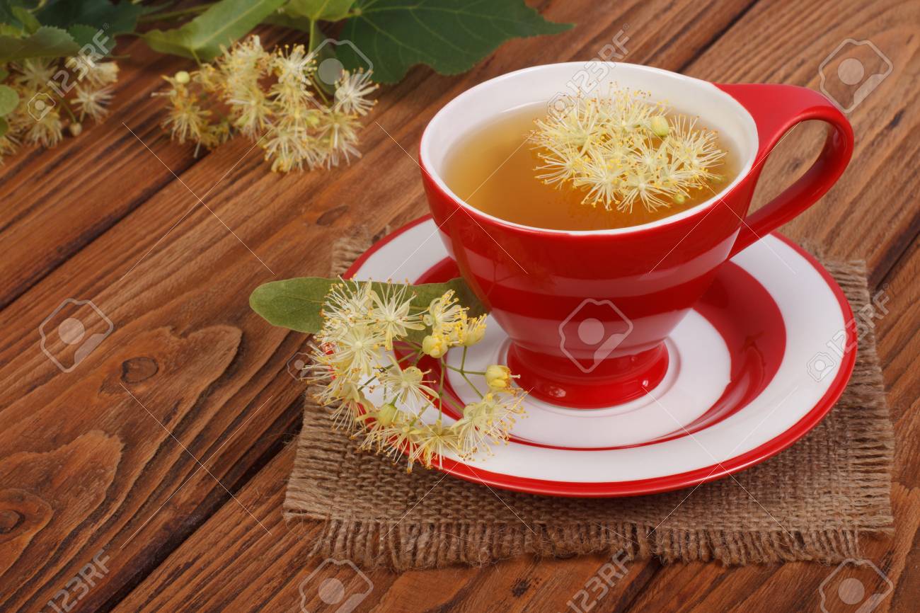 茶色の木製のテーブルにシナノキの花とハーブティー の写真素材 画像素材 Image