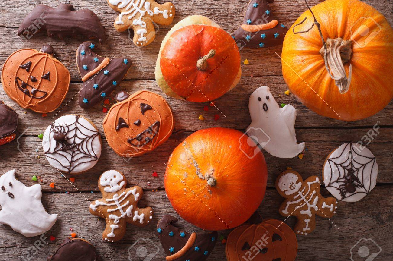 Beautiful gingerbread for Halloween and fresh pumpkin on the table. horizontal view from above - 45464184 Beautiful gingerbread for Halloween and fresh pumpkin on the table. horizontal view from above - 45464184