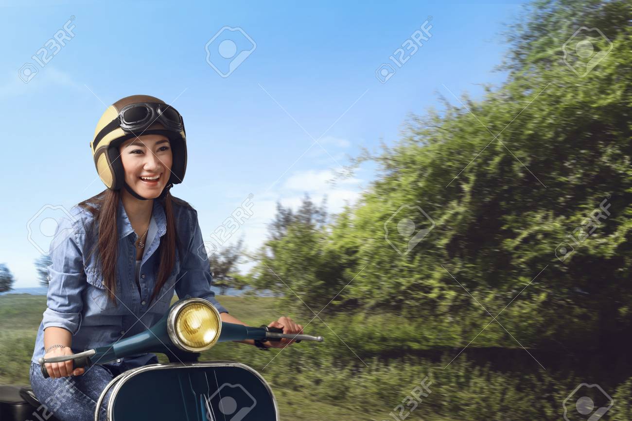 Mujer De La Moto En La Vespa Con El Casco Foto de archivo Mujer De La Moto En La Vespa Con El Casco Foto de archivo