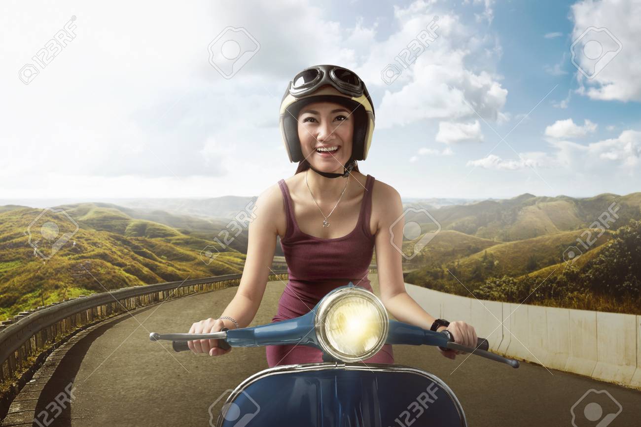 Mujer De La Moto En La Vespa Con El Casco Foto de archivo Mujer De La Moto En La Vespa Con El Casco Foto de archivo