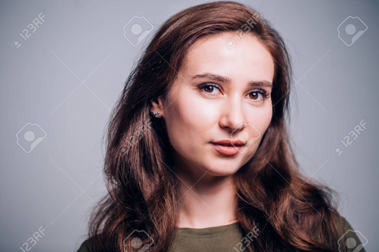 Horizontal close-up portrait of beautiful brunette woman on grey background. student girl. Emotional happy expression - 131310190 Horizontal close-up portrait of beautiful brunette woman on grey background. student girl. Emotional happy expression - 131310190