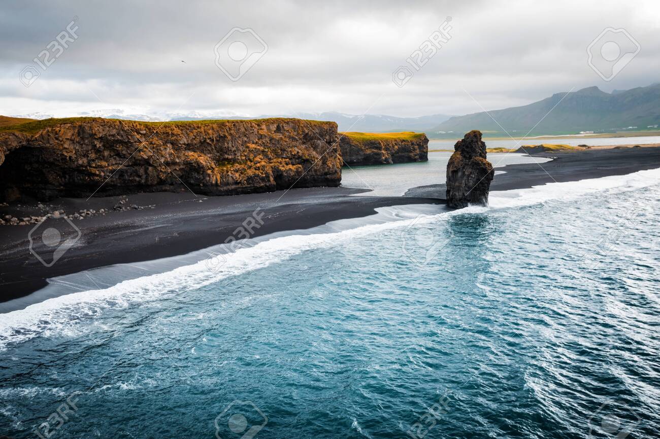 View on Kirkjufjara beach and Arnardrangur cliff. Location Myrdal valley, Atlantic ocean near Vik village, Iceland, Europe. Scenic image of amazing nature landscape. Discover the beauty of earth. - 123397087 View on Kirkjufjara beach and Arnardrangur cliff. Location Myrdal valley, Atlantic ocean near Vik village, Iceland, Europe. Scenic image of amazing nature landscape. Discover the beauty of earth. - 123397087