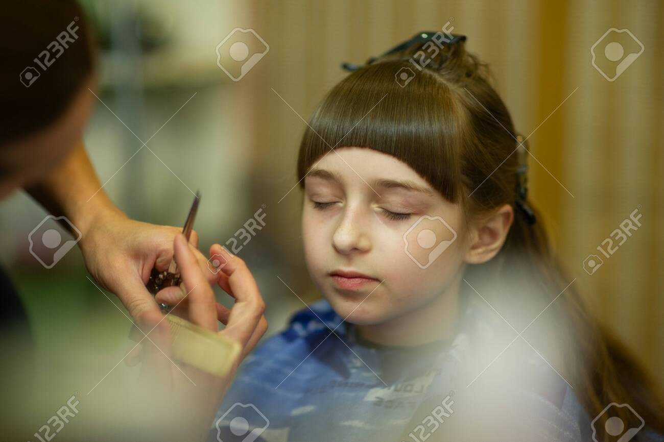 Hairdresser Making A Hair Style To Cute Little Girl The Girl