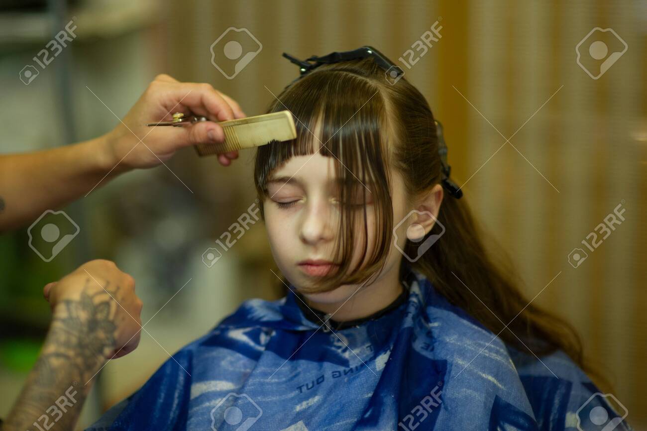 Hairdresser Making A Hair Style To Cute Little Girl The Girl