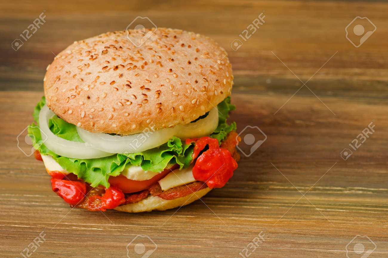 Preparation of delicious burger in a restaurant. Delicious burger on wood table background. Healthy chicken hamburger - 149834169 Preparation of delicious burger in a restaurant. Delicious burger on wood table background. Healthy chicken hamburger - 149834169