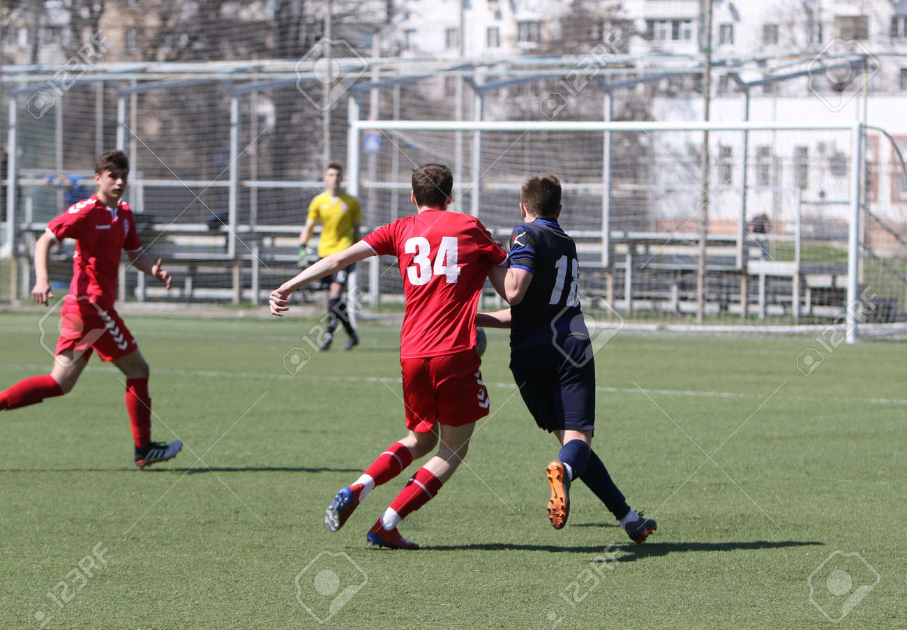 Odessa, Ukraine - April 11, 2021: Local children's football teams U-17 play on artificial grass of stadium. Football on field with artificial grass for soccer games. Children are playing football - 167999635 Odessa, Ukraine - April 11, 2021: Local children's football teams U-17 play on artificial grass of stadium. Football on field with artificial grass for soccer games. Children are playing football - 167999635