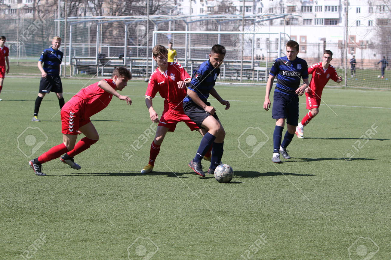 Odessa, Ukraine - April 11, 2021: Local children's football teams U-17 play on artificial grass of stadium. Football on field with artificial grass for soccer games. Children are playing football - 167999636 Odessa, Ukraine - April 11, 2021: Local children's football teams U-17 play on artificial grass of stadium. Football on field with artificial grass for soccer games. Children are playing football - 167999636