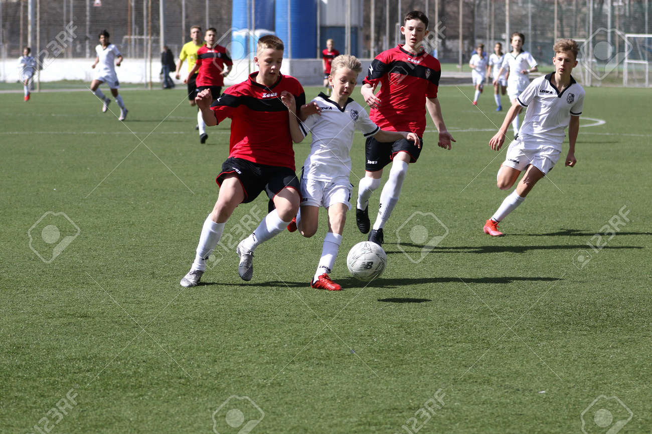 Odessa, Ukraine - April 7, 2021: Local children's football teams U-14 play on artificial grass of stadium. Football on field with artificial grass for soccer games. Children are playing football - 167820164 Odessa, Ukraine - April 7, 2021: Local children's football teams U-14 play on artificial grass of stadium. Football on field with artificial grass for soccer games. Children are playing football - 167820164