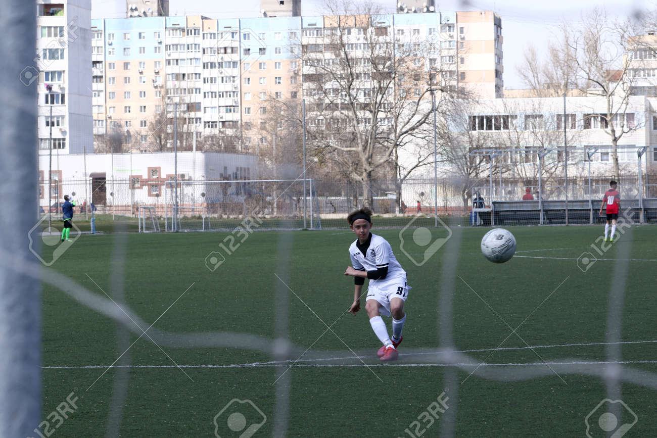 Odessa, Ukraine - April 7, 2021: Local children's football teams U-14 play on artificial grass of stadium. Football on field with artificial grass for soccer games. Children are playing football - 167820139 Odessa, Ukraine - April 7, 2021: Local children's football teams U-14 play on artificial grass of stadium. Football on field with artificial grass for soccer games. Children are playing football - 167820139