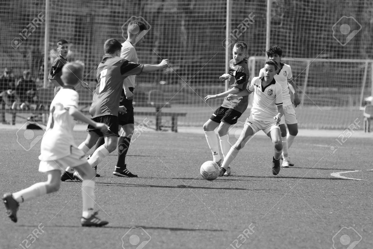 Odessa, Ukraine - April 7, 2021: Local children's football teams U-14 play on artificial grass of stadium. Football on field with artificial grass for soccer games. Children are playing football - 167820140 Odessa, Ukraine - April 7, 2021: Local children's football teams U-14 play on artificial grass of stadium. Football on field with artificial grass for soccer games. Children are playing football - 167820140