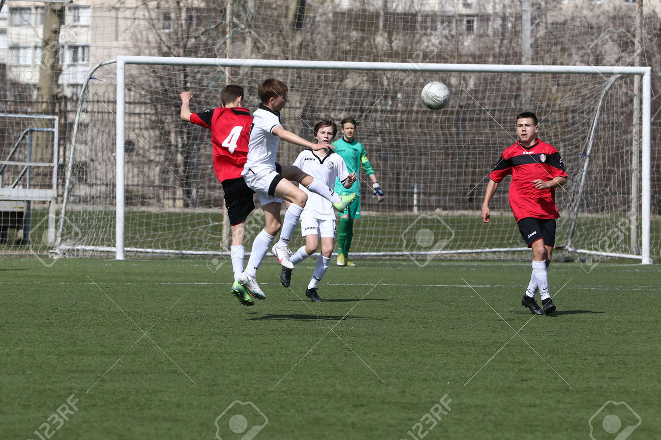 Odessa, Ukraine - April 7, 2021: Local children's football teams U-14 play on artificial grass of stadium. Football on field with artificial grass for soccer games. Children are playing football - 167820168 Odessa, Ukraine - April 7, 2021: Local children's football teams U-14 play on artificial grass of stadium. Football on field with artificial grass for soccer games. Children are playing football - 167820168