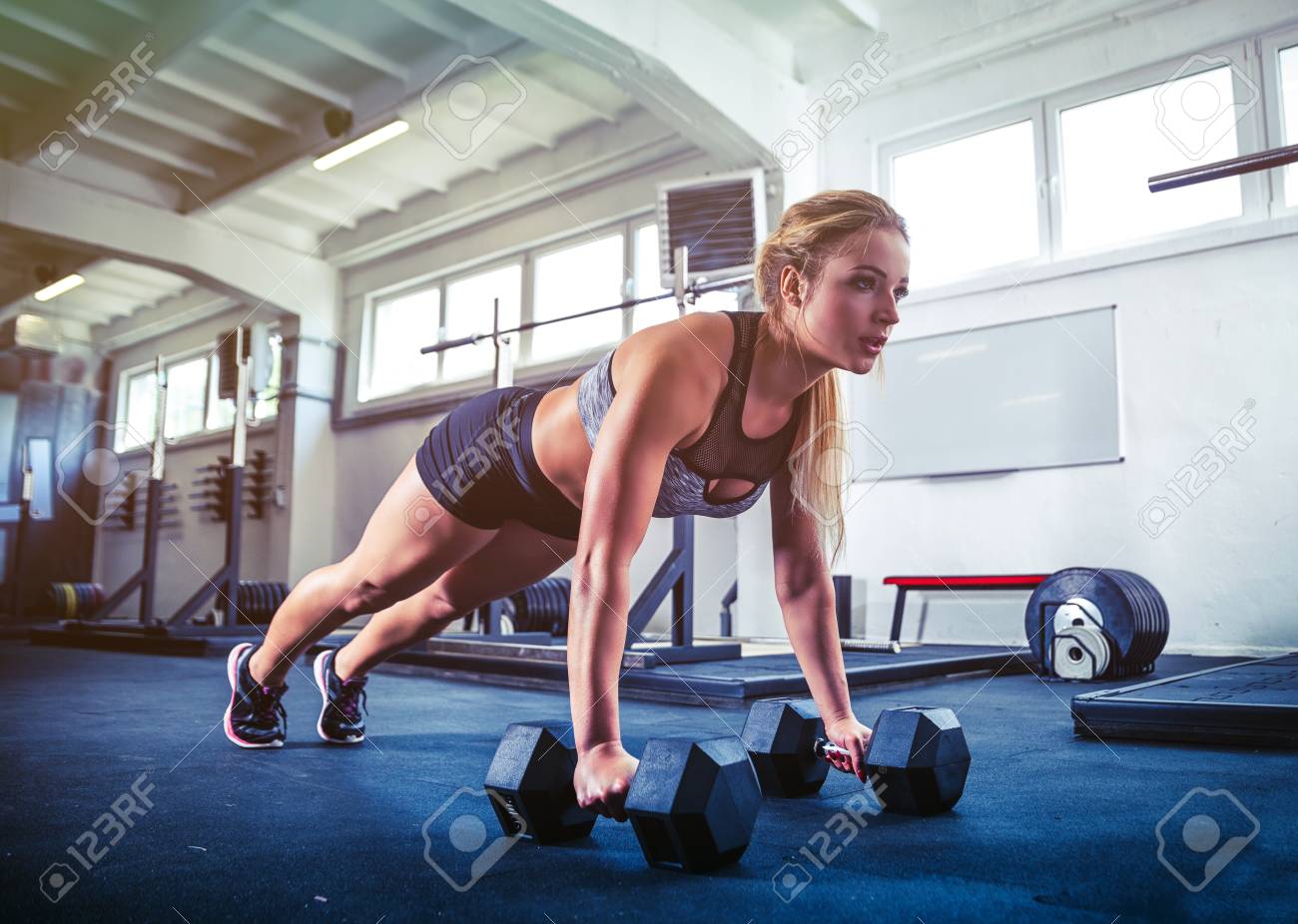 フィットネス女性ダンベル プッシュを行うワークアウト ジムでトレーニングをアップ の写真素材 画像素材 Image