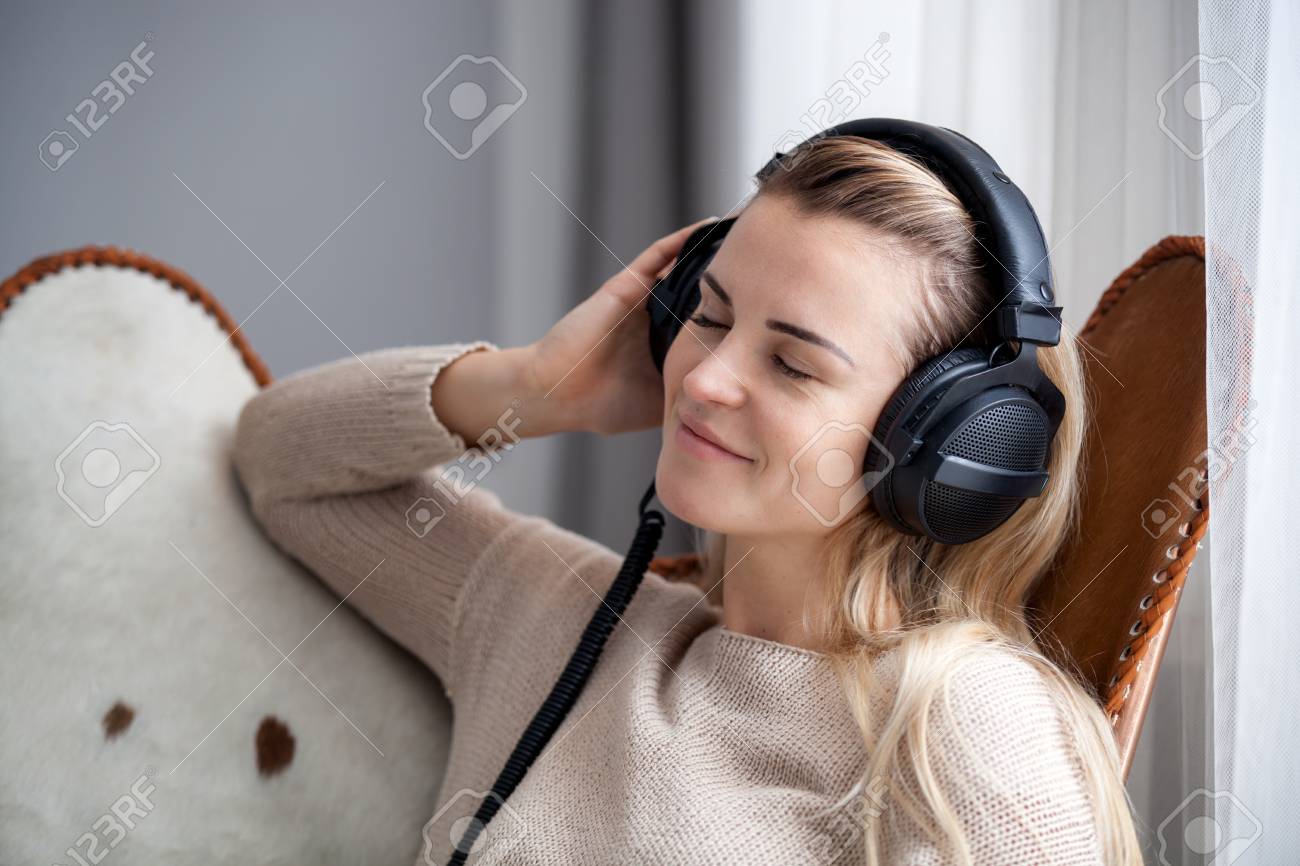Young Woman Wearing Headphones Listening To Music And Relaxing At Home  Stock Photo, Picture and Royalty Free Image. Image 114261953., image size:1300x866