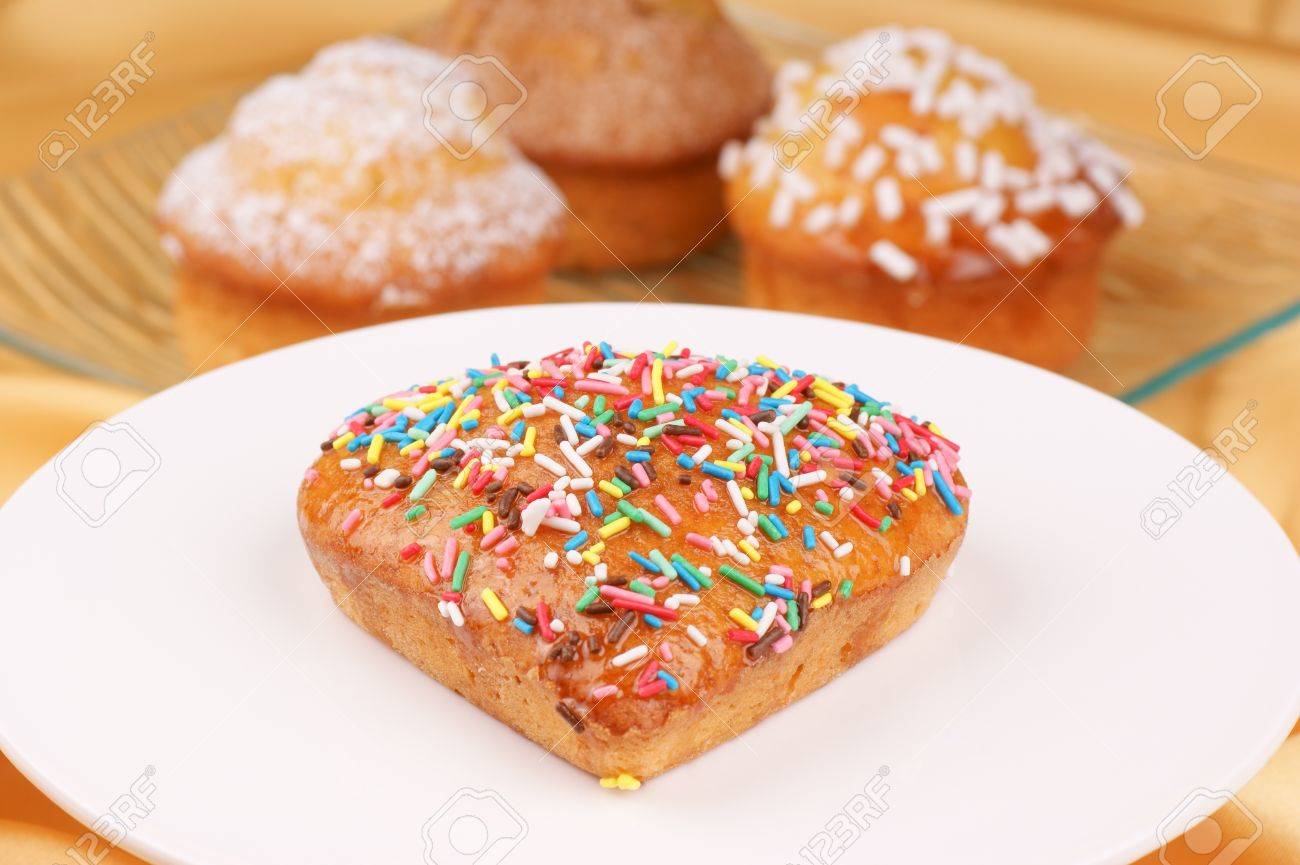 Petit Coeur En Forme De Gateau Decore Avec Des Grains De Sucre Colores Servi Sur Un Stand Gateau Blanc Assortiment De Muffins Sur Une Plaque De Verre Sont De Mise Au Point