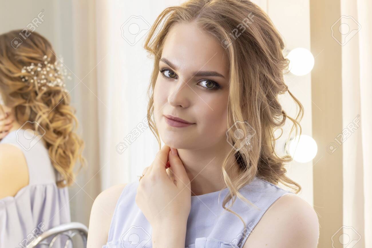 Beautiful Girl With A Wedding Hairstyle Looks At Herself In The