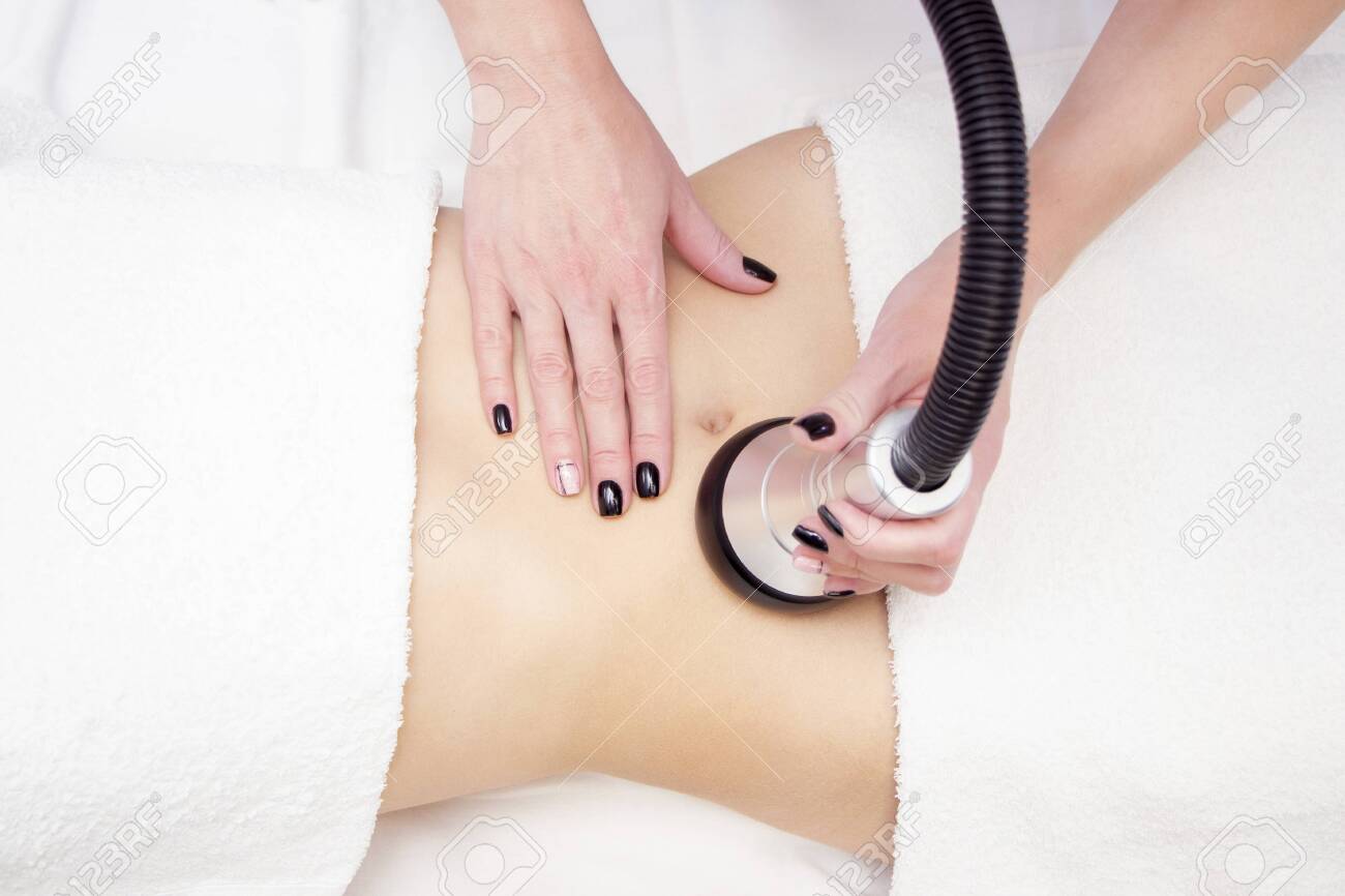procedure removing cellulite on female abdomen, cavitation belly massage. Ultrasonic massage for weight loss. Correction of female figure without surgical intervention. Closeup of the tummy. - 134039019 procedure removing cellulite on female abdomen, cavitation belly massage. Ultrasonic massage for weight loss. Correction of female figure without surgical intervention. Closeup of the tummy. - 134039019