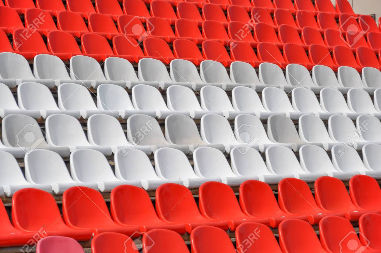 Empty seats in the stands of the arena. Rows of red and white stadium seats without spectators. The concept of the abolition of sports and mass entertainment events - 146743351 Empty seats in the stands of the arena. Rows of red and white stadium seats without spectators. The concept of the abolition of sports and mass entertainment events - 146743351