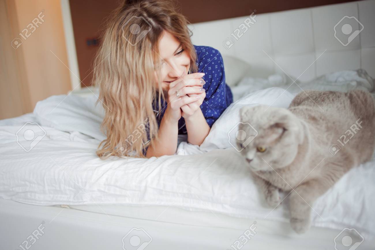 Portrait D Une Belle Femme En Pyjama A La Maison Couche Dans Son Lit Pat Le Chat Banque D Images Et Photos Libres De Droits Image