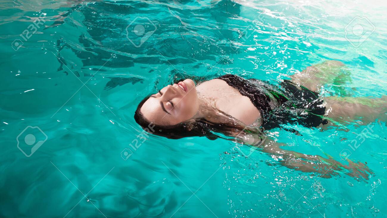 Beautiful Girl Is Relaxing In The Spa Pool Swim And Relax Young Woman Floating In Water On The Back Stock Photo Picture And Royalty Free Image Image 142527658