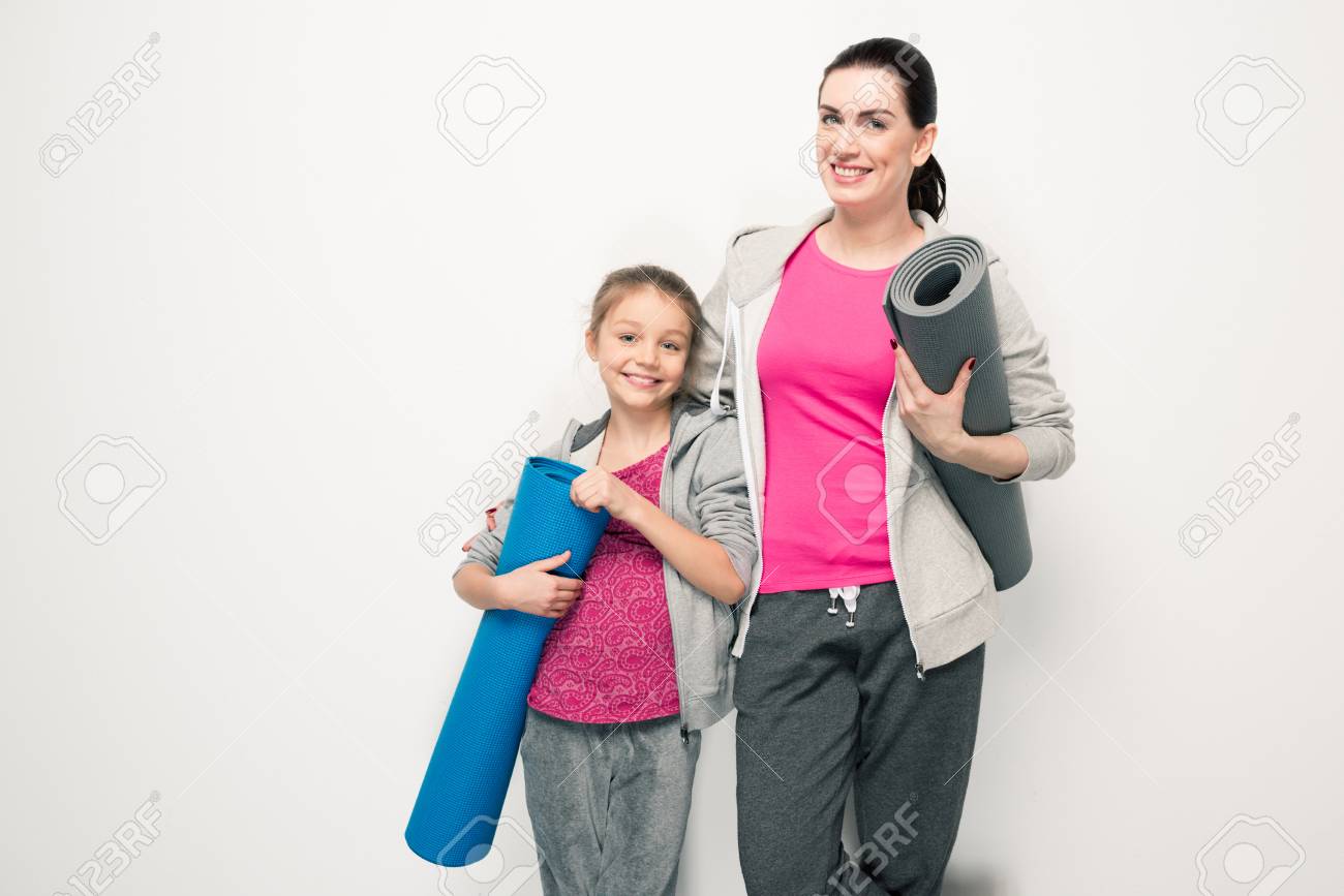 Madre E Hija En Ropa Deportiva Con Colchonetas De Yoga Y Sonriendo A La  Cámara Fotos, retratos, imágenes y fotografía de archivo libres de derecho.  Image 77301816