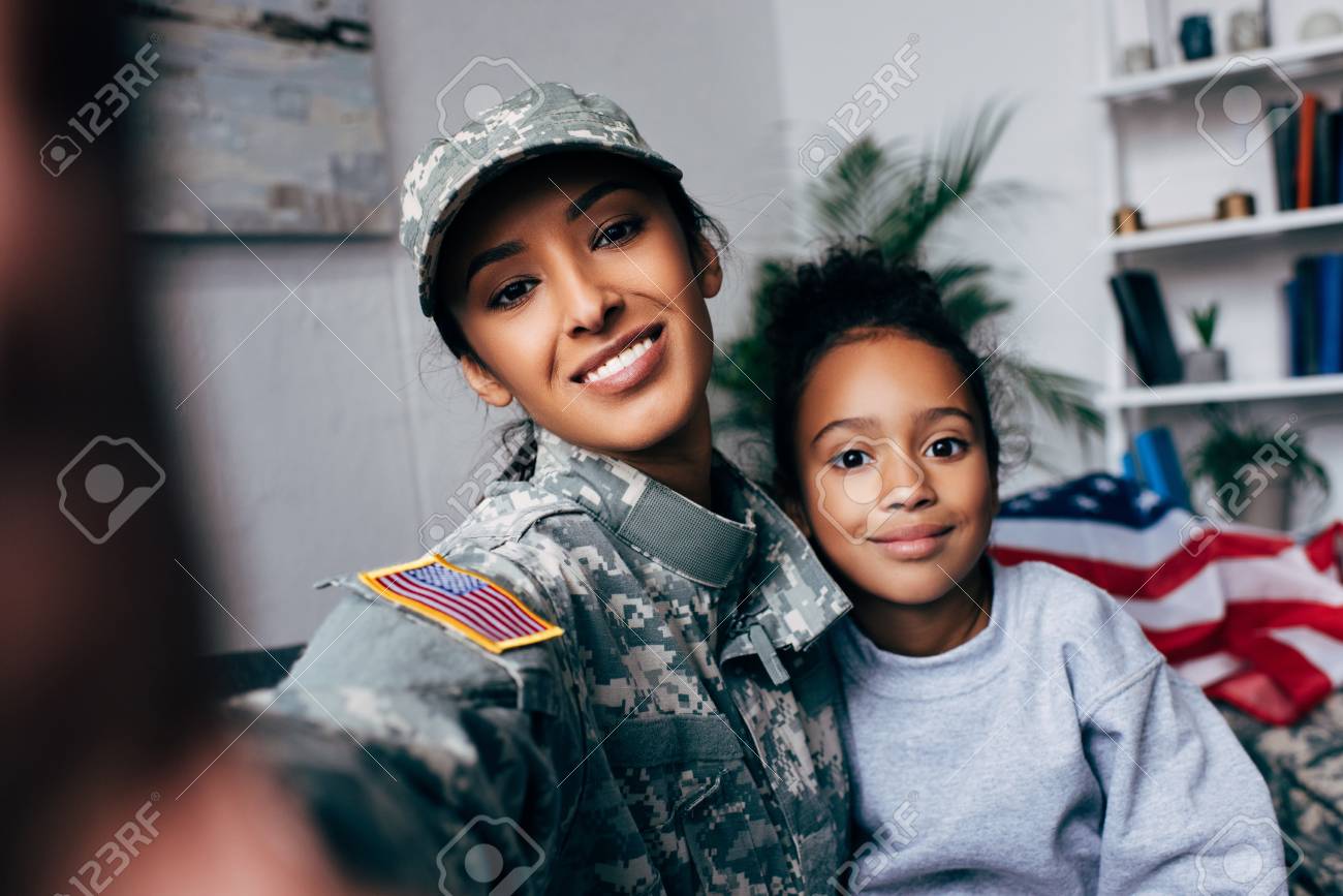 smiling african american daughter and soldier in military uniform taking selfie at home - 102611965 smiling african american daughter and soldier in military uniform taking selfie at home - 102611965