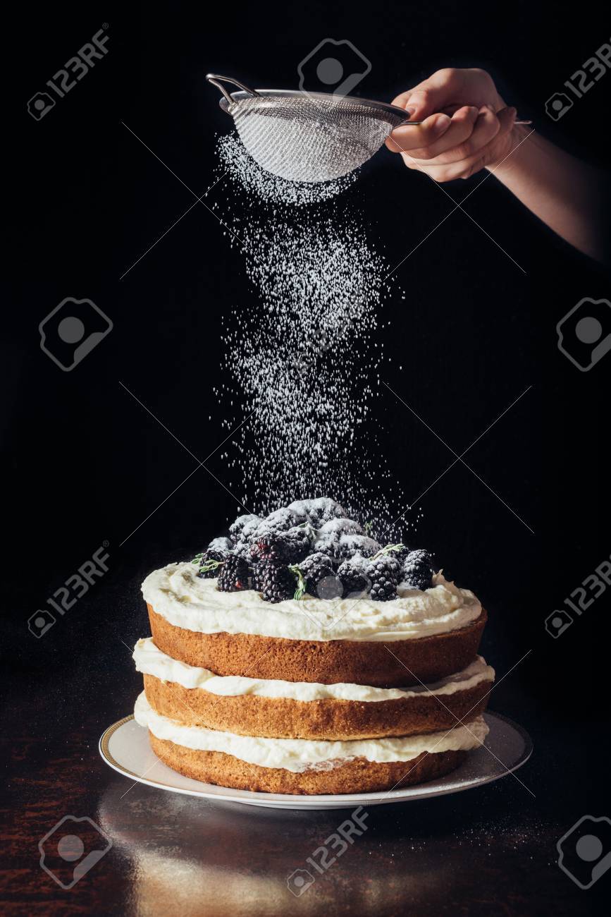 cropped shot of woman spilling sugar powder onto delicious blackberry on black - 106420426 cropped shot of woman spilling sugar powder onto delicious blackberry on black - 106420426