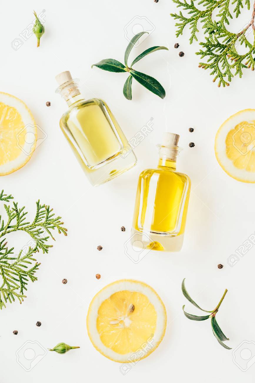 top view of bottles of fresh perfume with green branches and lemon slices on white - 106586367 top view of bottles of fresh perfume with green branches and lemon slices on white - 106586367