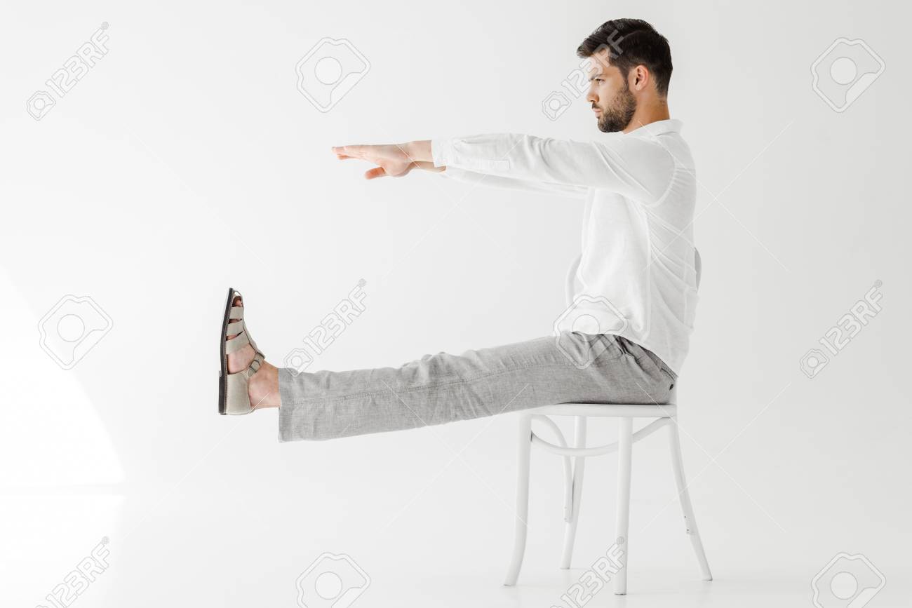 Side View Of Male Model In Linen Clothes Sitting On Chair With