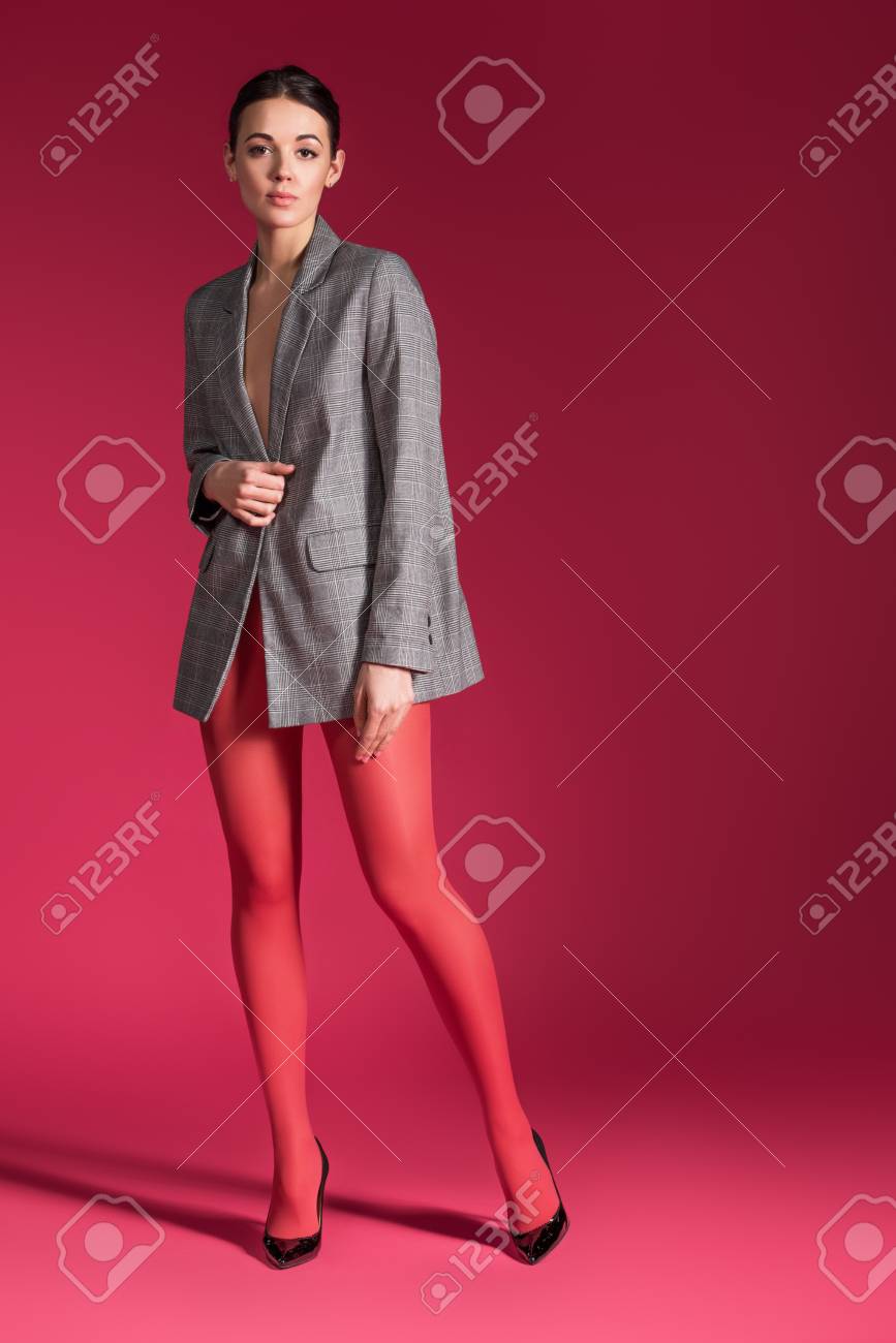 Sensual Woman In Red Nylon Tights Wearing Grey Jacket On Red