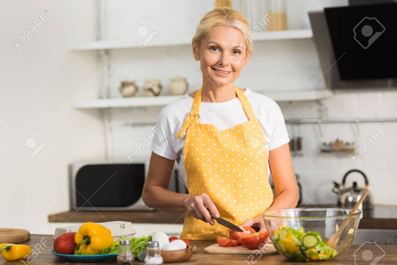 Mature Woman In Apron Smiling At Camera