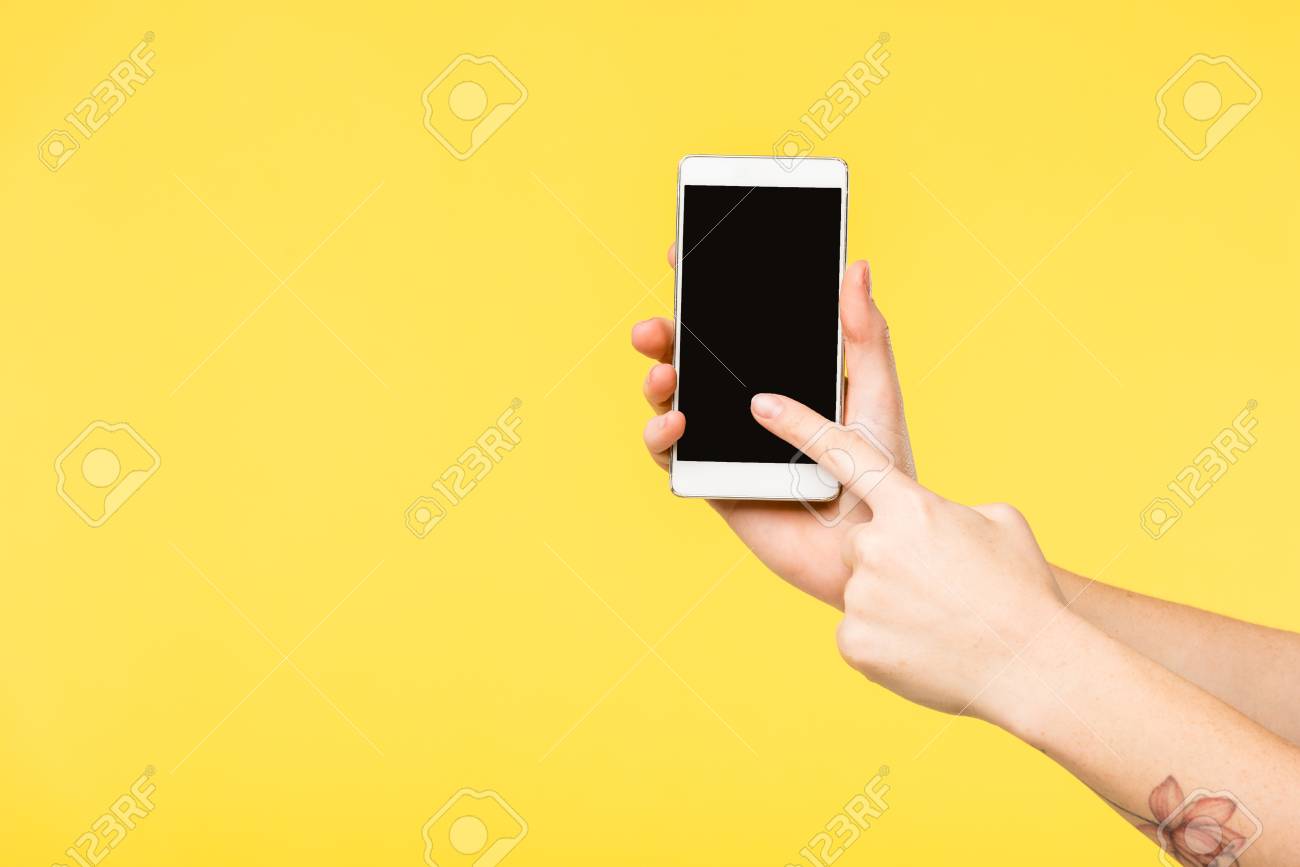 黄色で隔離された黒い画面でスマートフォンを持っている人のトリミングショット の写真素材 画像素材 Image 黄色で隔離された黒い画面でスマートフォンを持っている人のトリミングショット の写真素材 画像素材 Image
