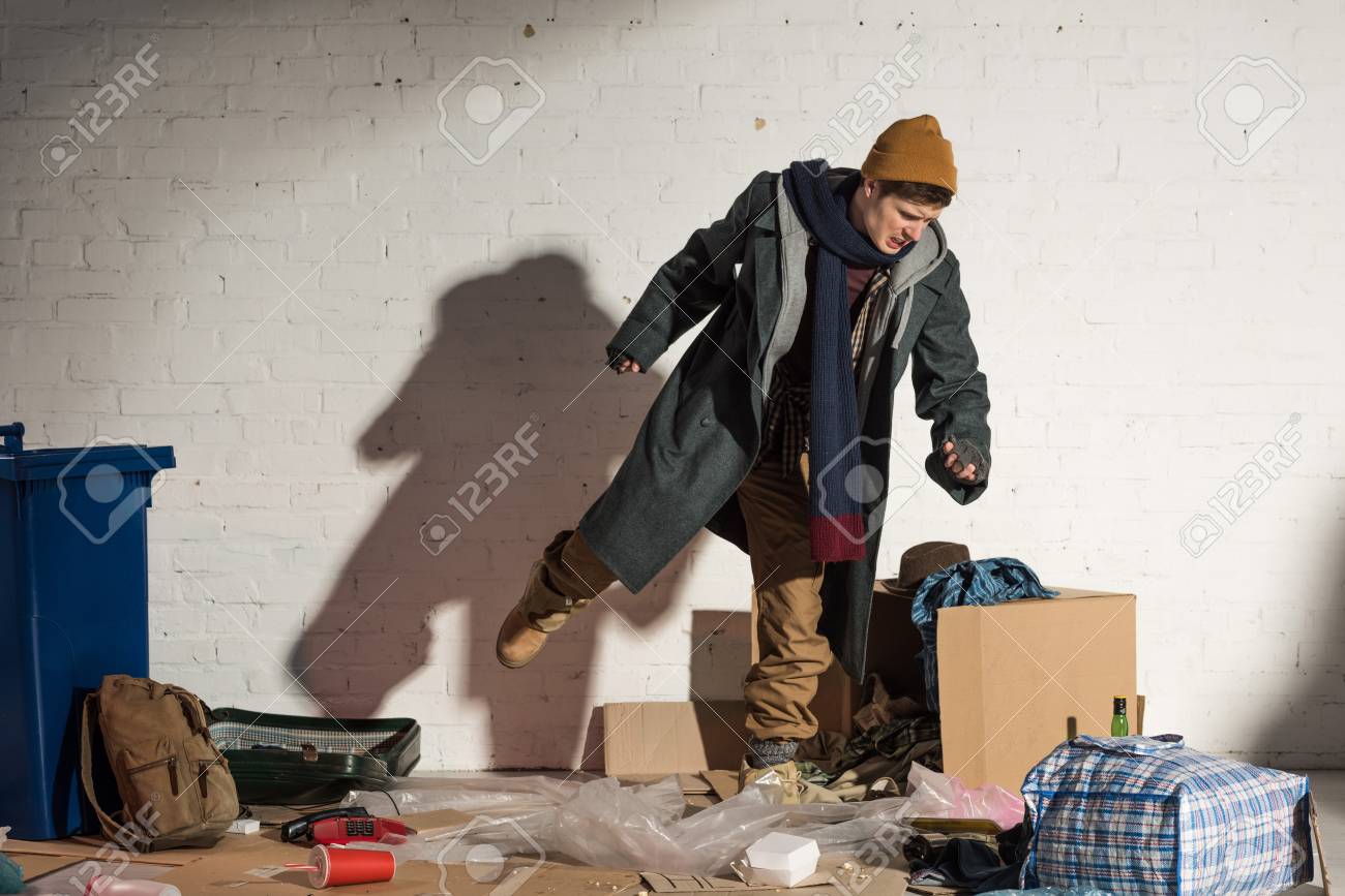 117876366-angry-homeless-man-kicking-cardboard-box-with-garbage.jpg