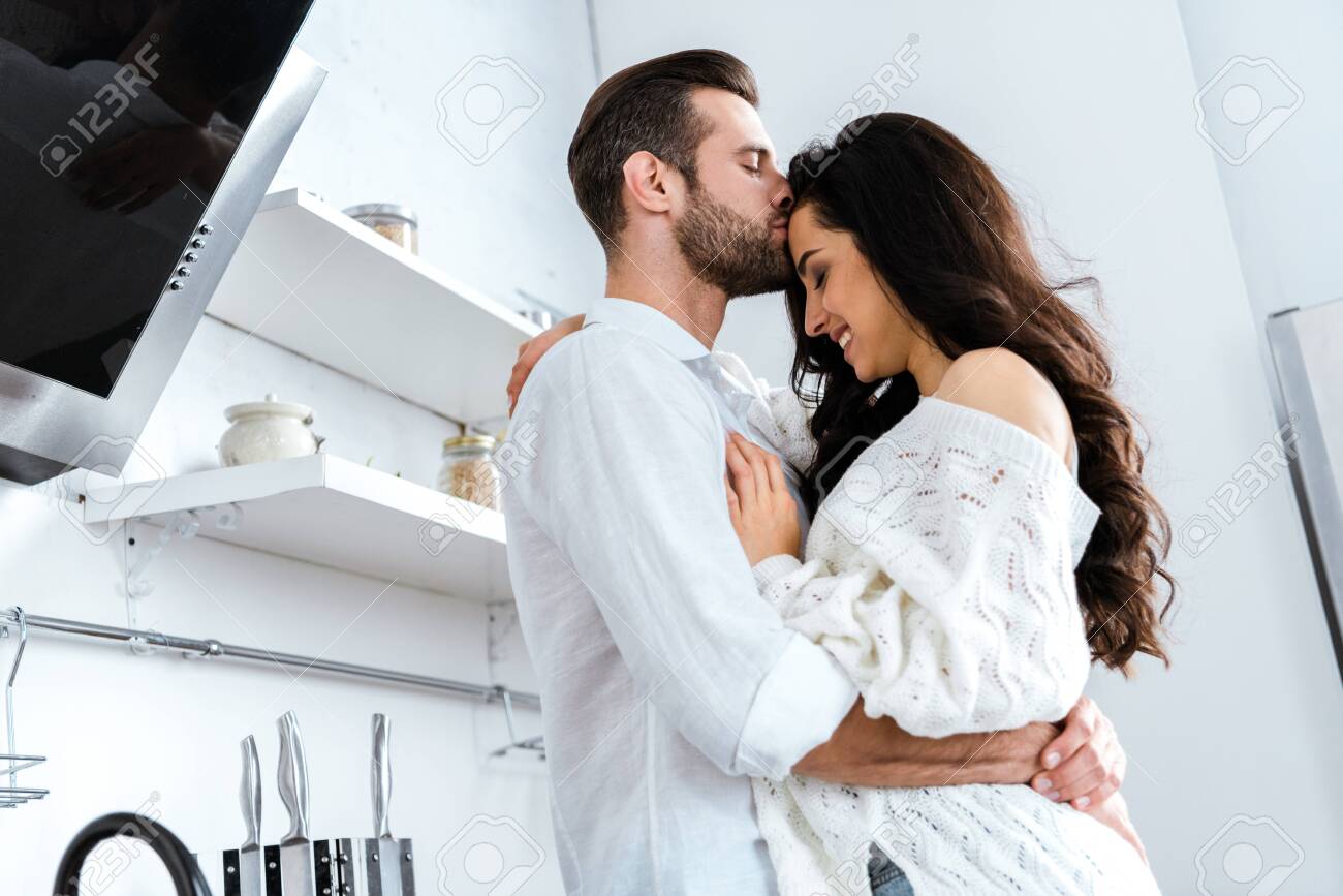 Man with closed eyes gently hugging and kissing woman - 127543721 Man with closed eyes gently hugging and kissing woman - 127543721