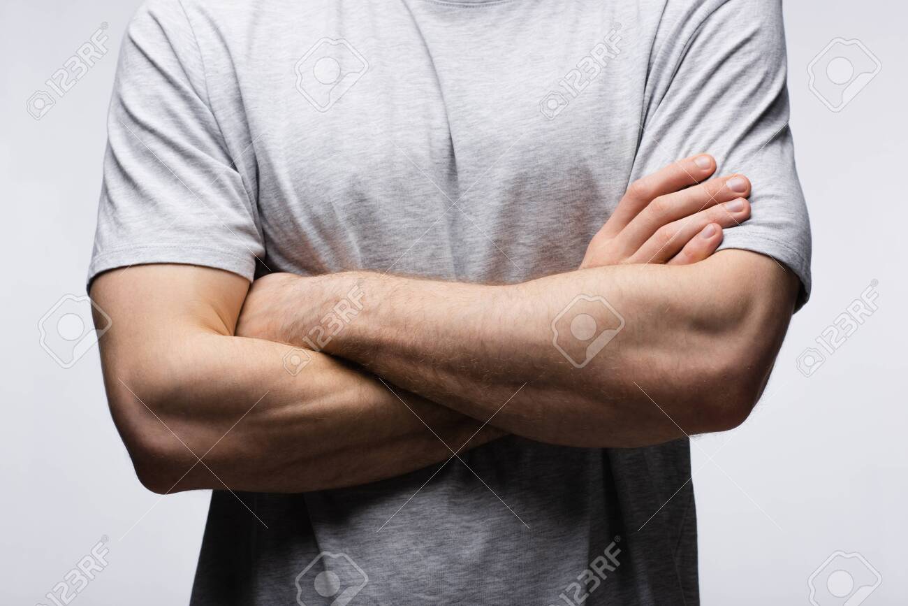 cropped view of man standing with crossed arms isolated on grey, human emotion and expression concept - 128157739 cropped view of man standing with crossed arms isolated on grey, human emotion and expression concept - 128157739