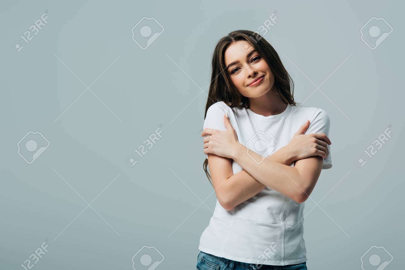 dreamy smiling beautiful girl in white t-shirt hugging herself isolated on grey - 130321814 dreamy smiling beautiful girl in white t-shirt hugging herself isolated on grey - 130321814