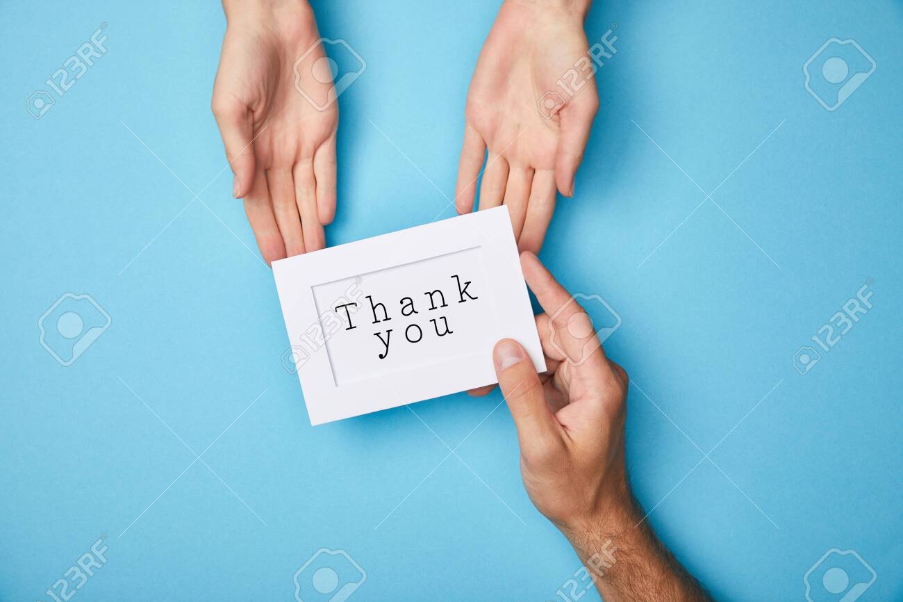 cropped view of man giving white card in frame with thank you lettering to woman on blue background - 130575491 cropped view of man giving white card in frame with thank you lettering to woman on blue background - 130575491