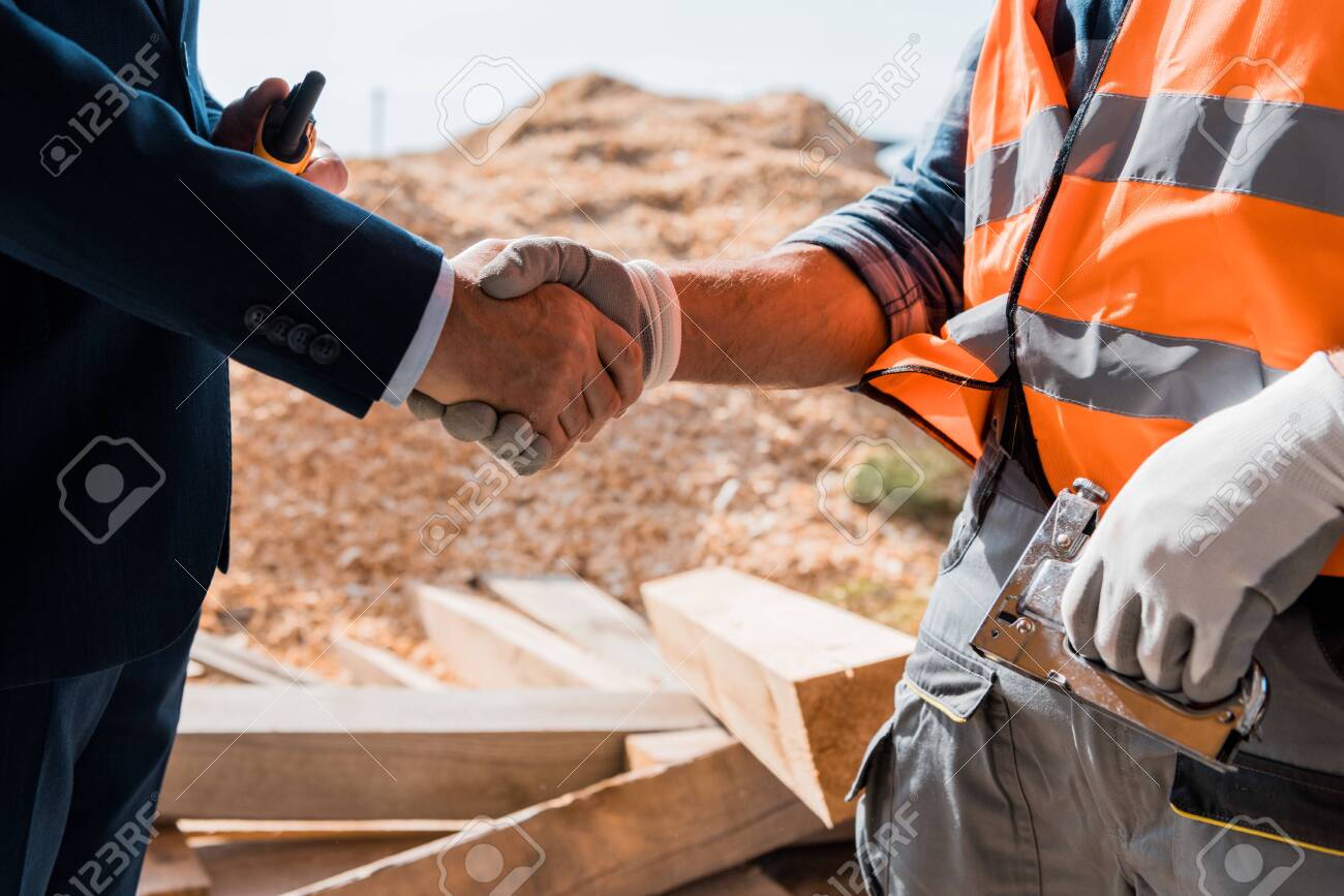 cropped view of constructor and businessman shaking hands - 131182878 cropped view of constructor and businessman shaking hands - 131182878