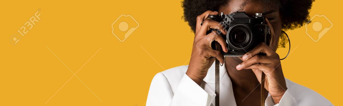 panoramic shot of curly african american woman covering face while taking photo isolated on orange - 132695815 panoramic shot of curly african american woman covering face while taking photo isolated on orange - 132695815