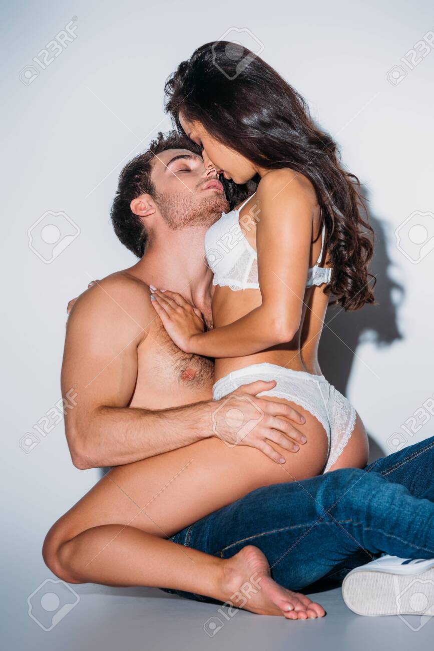 Sexy Girl In White Lingerie Hugging And Kissing Shirtless Boyfriend On Grey  Background Stock Photo, Picture and Royalty Free Image. Image 132905075.