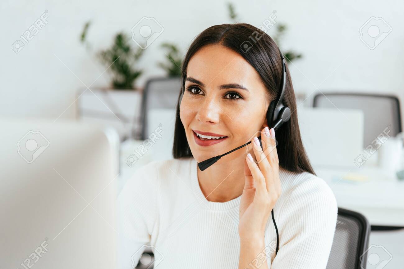 selective focus of attractive broker touching headset while working in call center - 134010992 selective focus of attractive broker touching headset while working in call center - 134010992