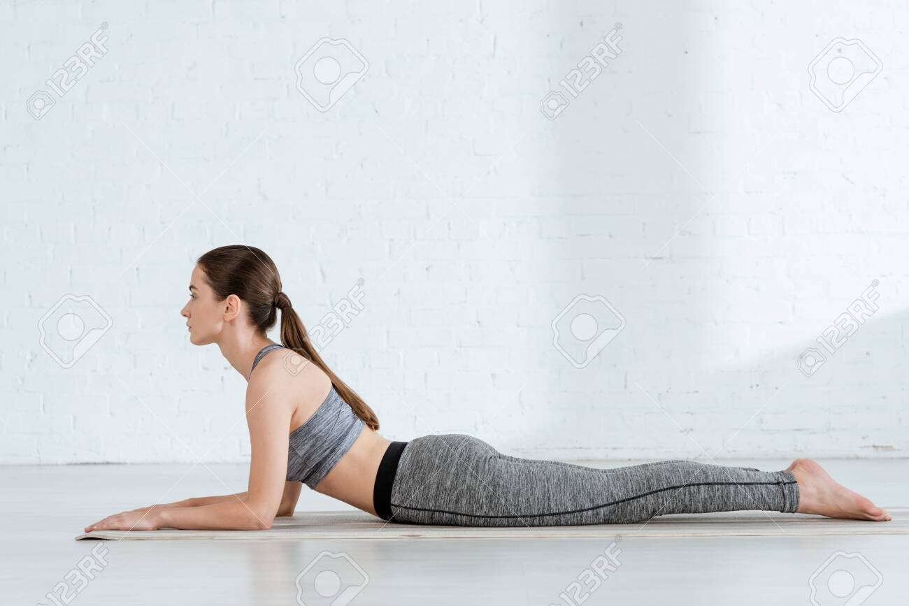side view of young woman in sportswear practicing yoga in sphinx.. side view of young woman in sportswear practicing yoga in sphinx..