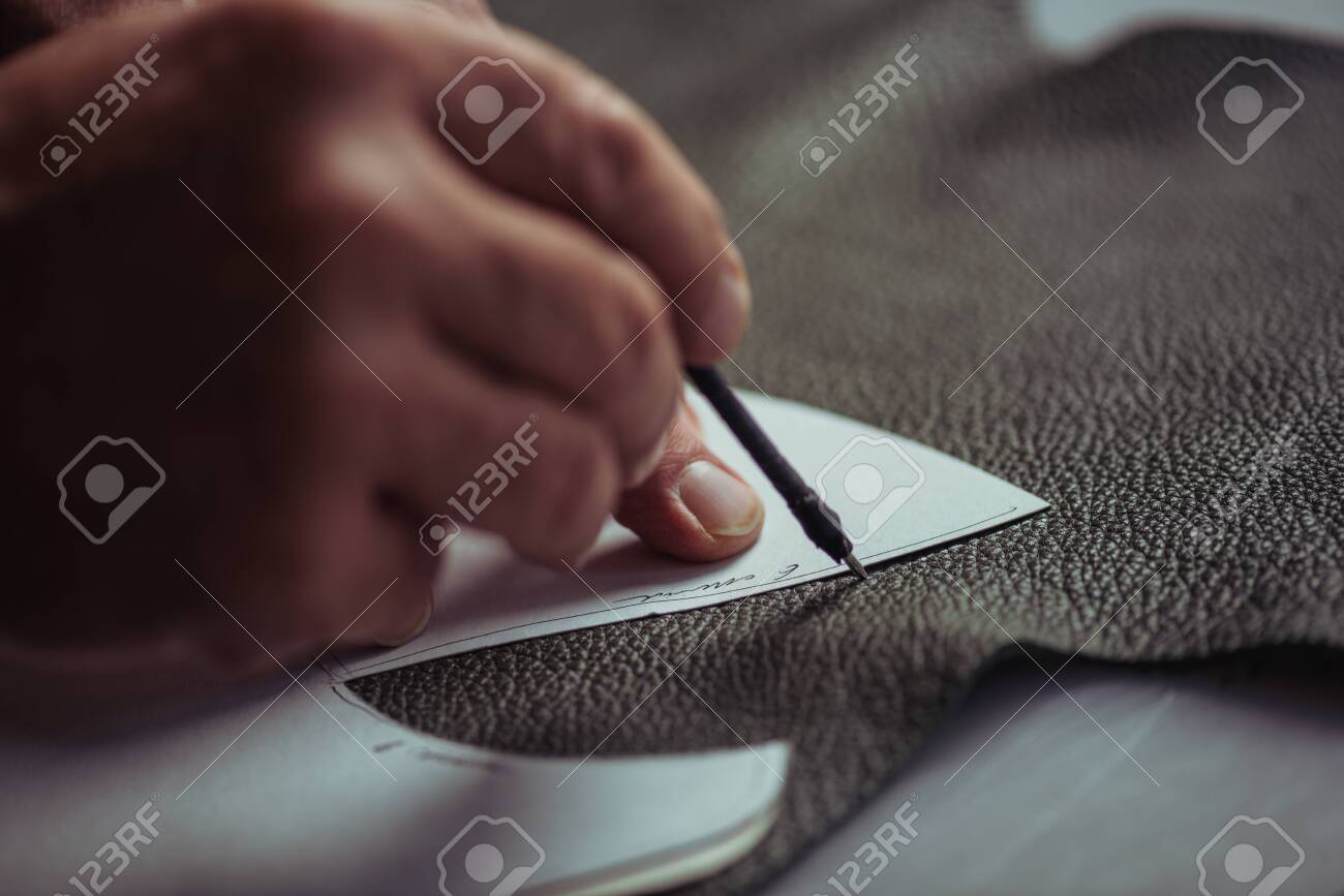 cropped view of cobbler marking leather with special pen near template - 139504508 cropped view of cobbler marking leather with special pen near template - 139504508