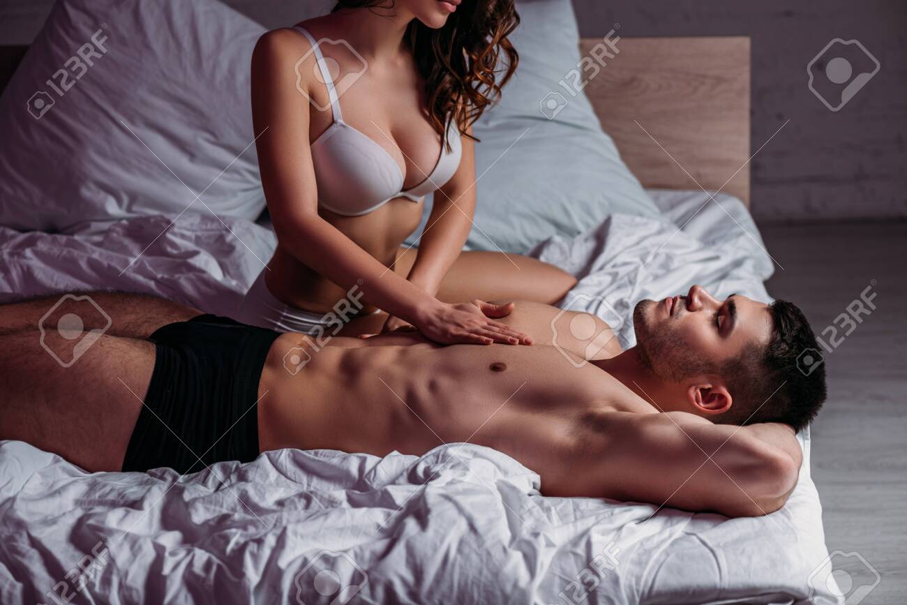 Cropped View Of Passionate Girl In White Bra Making Chest Erotic Massage To  Sexy Boyfriend Lying On Bed With Closed Eyes Stock Photo, Picture and  Royalty Free Image. Image 142572703.