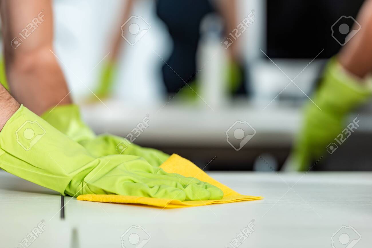 cropped view of man in rubber gloves cleaning desk surface with rag - 142861394 cropped view of man in rubber gloves cleaning desk surface with rag - 142861394