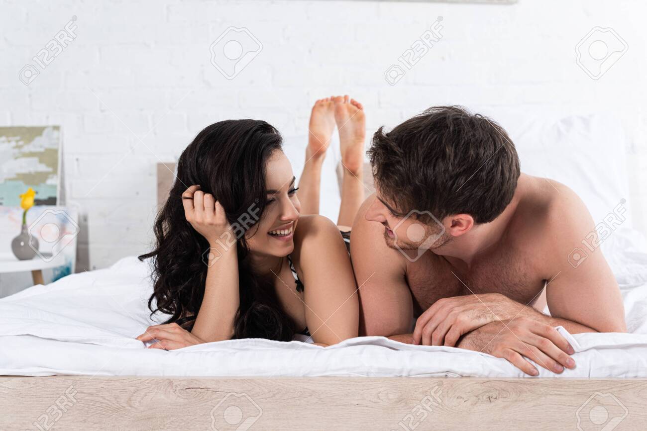 Boyfriend And Girlfriend Looking At Each Other, Smiling And Lying On Bed  Stock Photo, Picture and Royalty Free Image. Image 144081975.