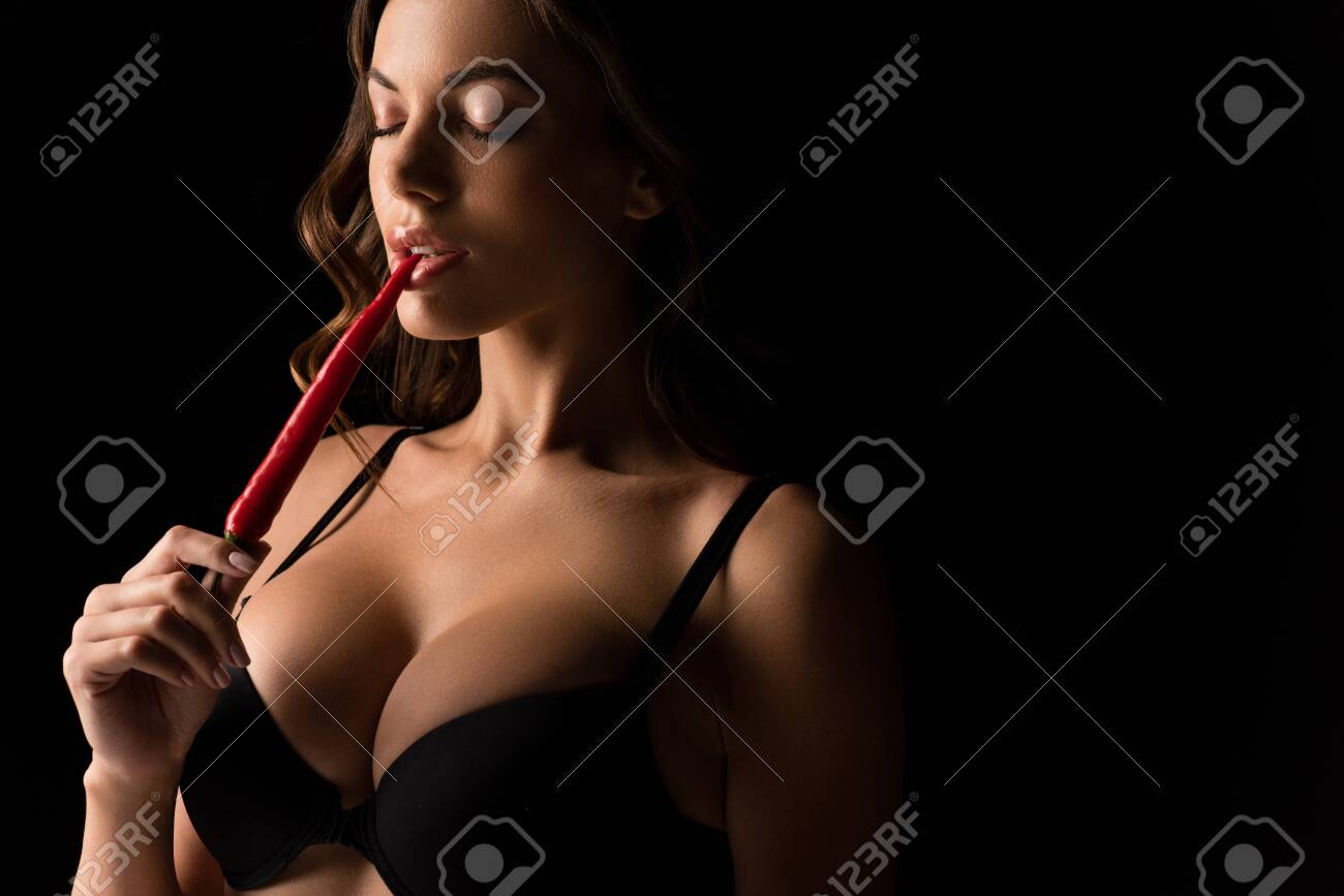 Sexy Girl With Big Breasts Touching Lips With Red Hot Chili Pepper Isolated  On Black Stock Photo, Picture and Royalty Free Image. Image 144158307.