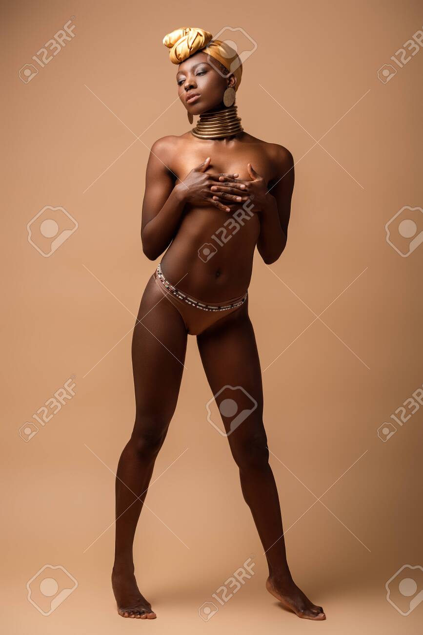 Sexy Naked Tribal Afro Woman Posing On Beige Stock Photo, Picture and  Royalty Free Image. Image 145423025.