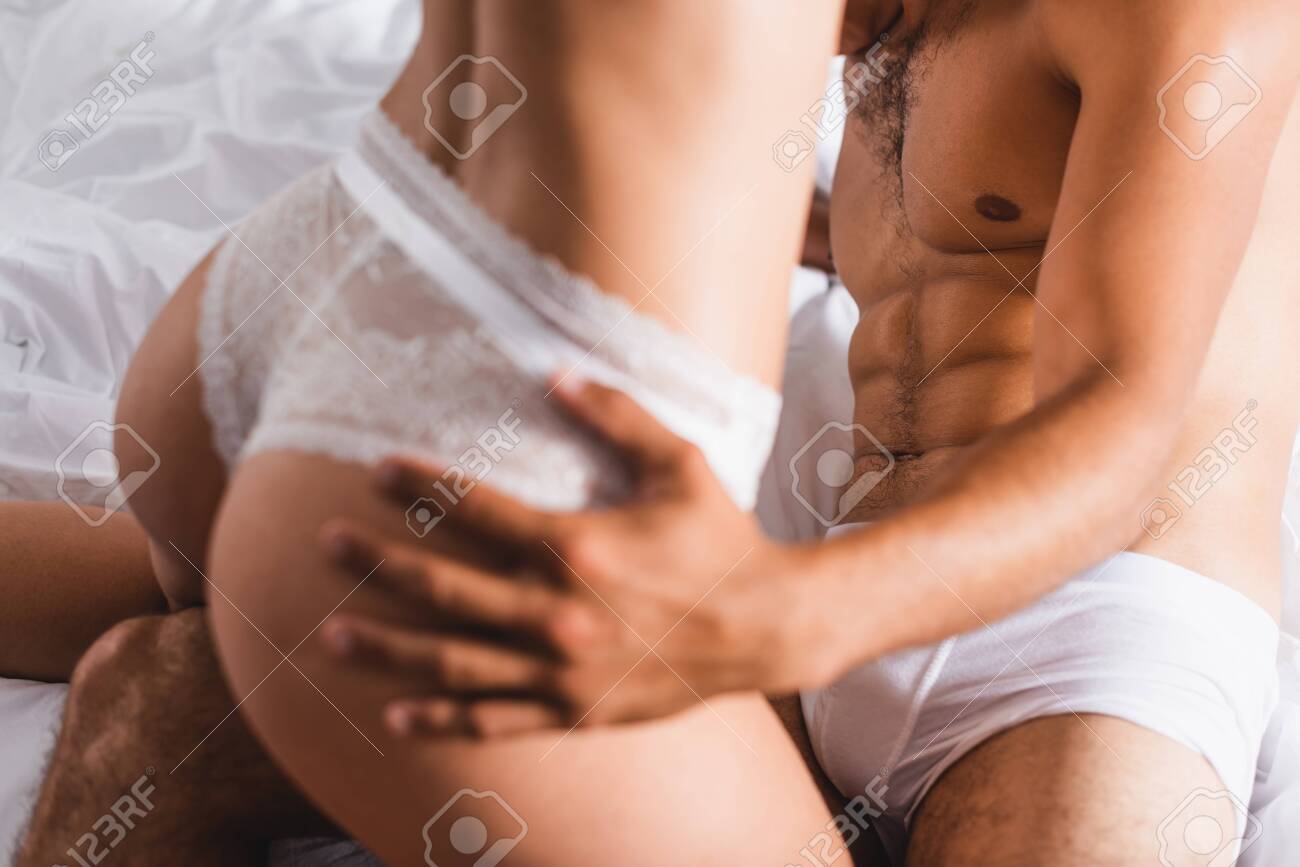 Cropped View Of Muscular Man Touching Butt Of Girlfriend In Panties On Bed Stock Photo, Picture and Royalty Free Image image