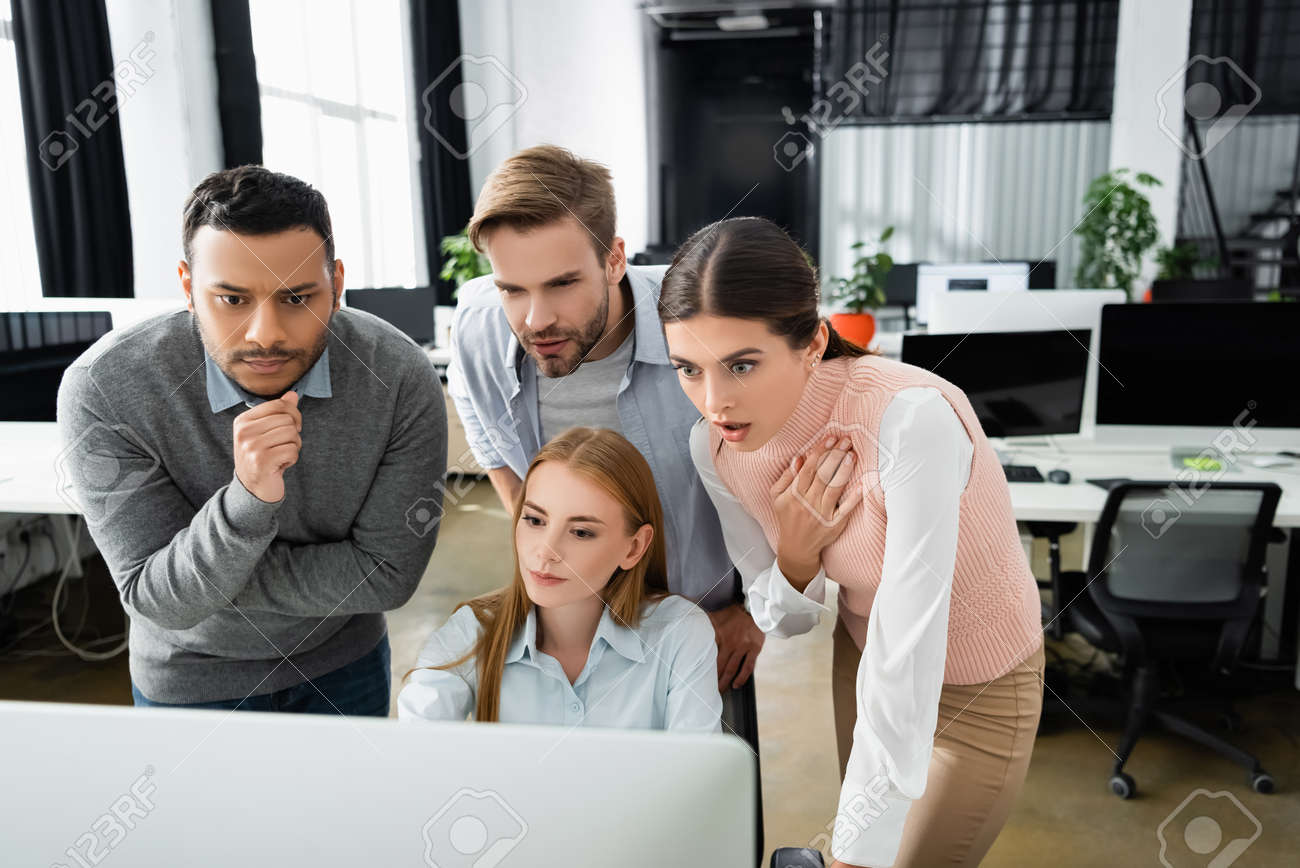 Excited multiethnic businesspeople looking at computer monitor on blurred foreground in office - 158496710 Excited multiethnic businesspeople looking at computer monitor on blurred foreground in office - 158496710