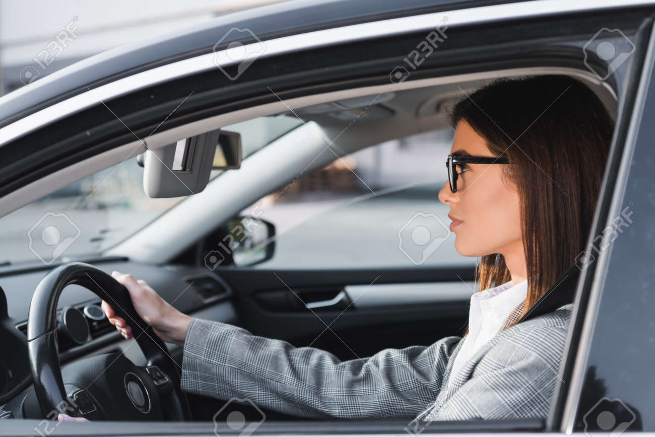 side view of businesswoman in eyeglasses looking ahead while driving car - 159979797 side view of businesswoman in eyeglasses looking ahead while driving car - 159979797